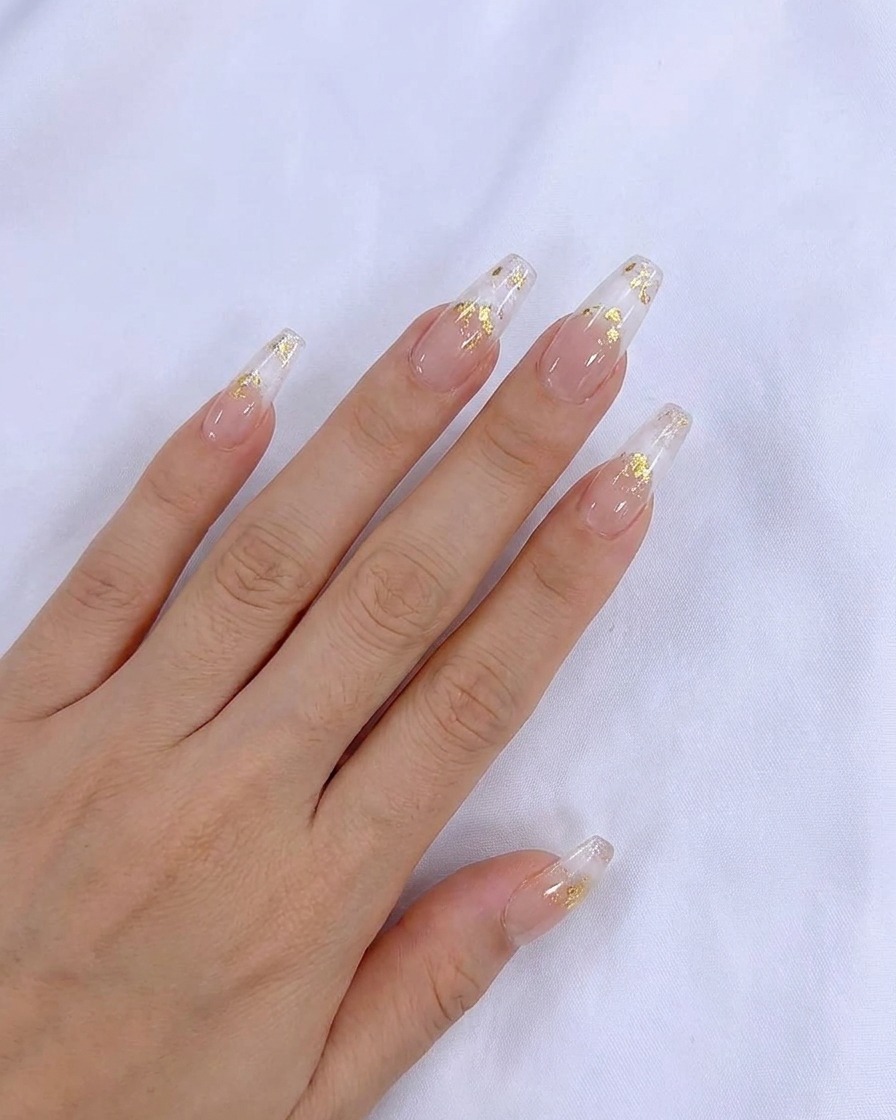 Ein Pinsel trägt eine glatte Schicht transparenten Nude-Gel-Lacks auf den Naturnagel auf.