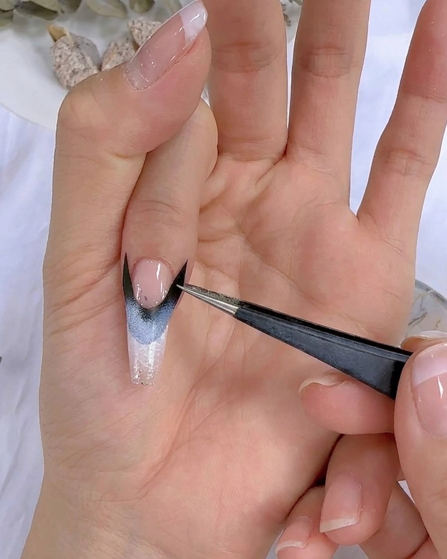 Nahaufnahme einer Hand mit Nageldesign unter einer UV-LED-Lampe.