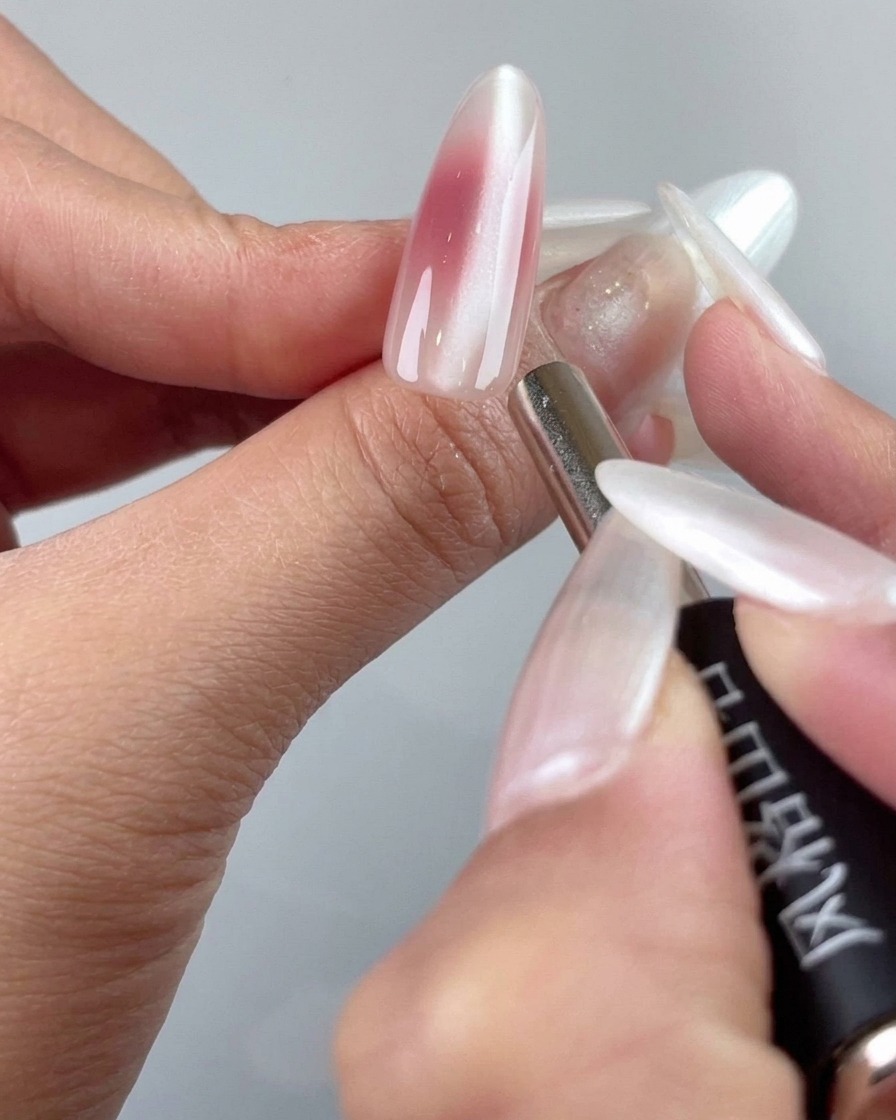 Ein feines Magnetwerkzeug verfeinert die Cat-Eye-Partikel in der Nähe der Nagelhaut.