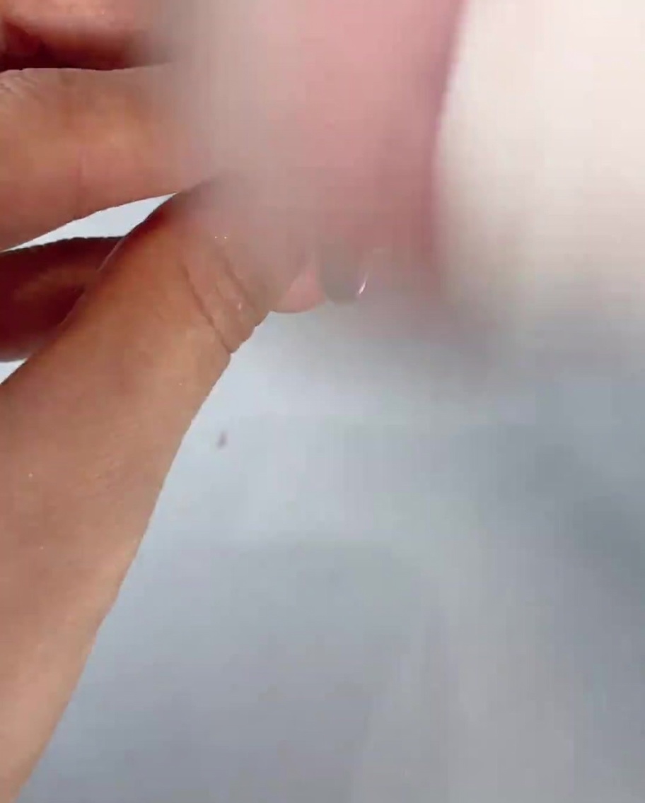 Ein weicher, flauschiger Pinsel fegt Puderstaubreste von einem manikürten Finger.