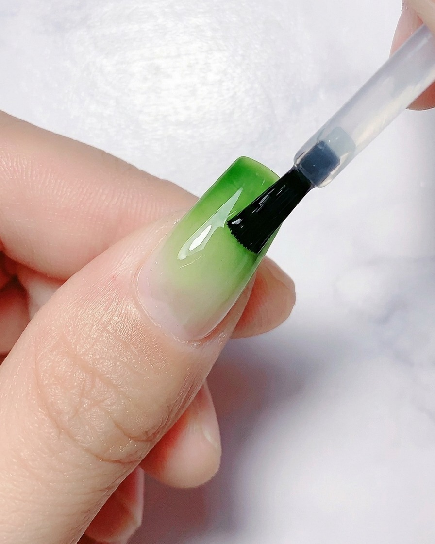 Eine Hand wird zum Aushärten unter einer UV-/LED-Nagellampe positioniert.