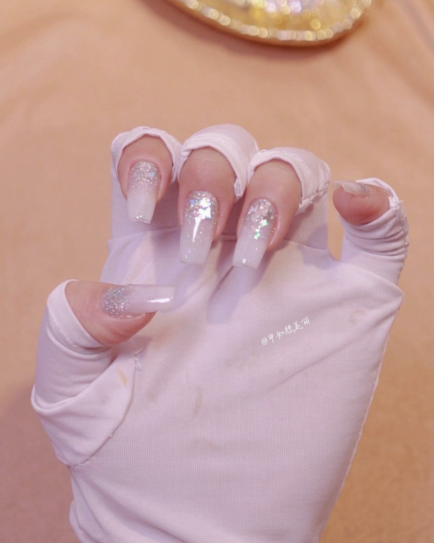 Eine Hand ist unter einer Nagellampe positioniert, um die frisch aufgetragene Nail-Art-Schicht auszuhärten.