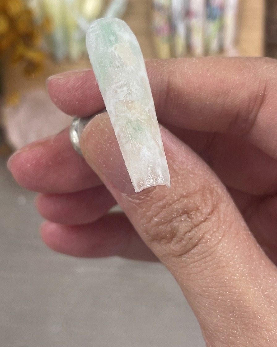 Eine Nahaufnahme eines perfekt gefeilten und mattierten Nagels mit einer glatten, milchig-matten Oberfläche.