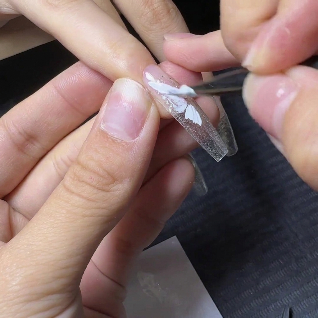 Ein Detailpinsel füllt den unteren Bereich des weißen Schmetterlingsflügel-Designs aus.
