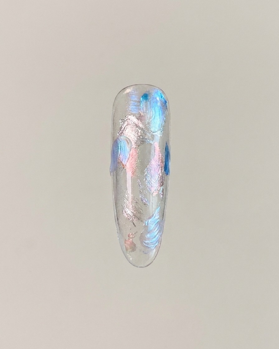 Eine Nagelspitze mit Cat-Eye-Gel, das zu einem glühenden Glaskugeleffekt in der Mitte magnetisiert wurde.
