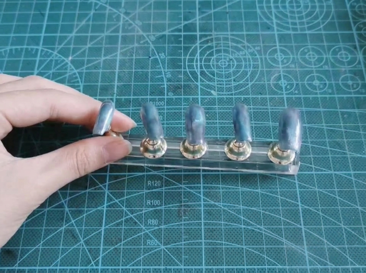 Fünf Nagelspitzen auf einem Display-Ständer zeigen eine fertige blau-lila Farbverlaufsbasis.