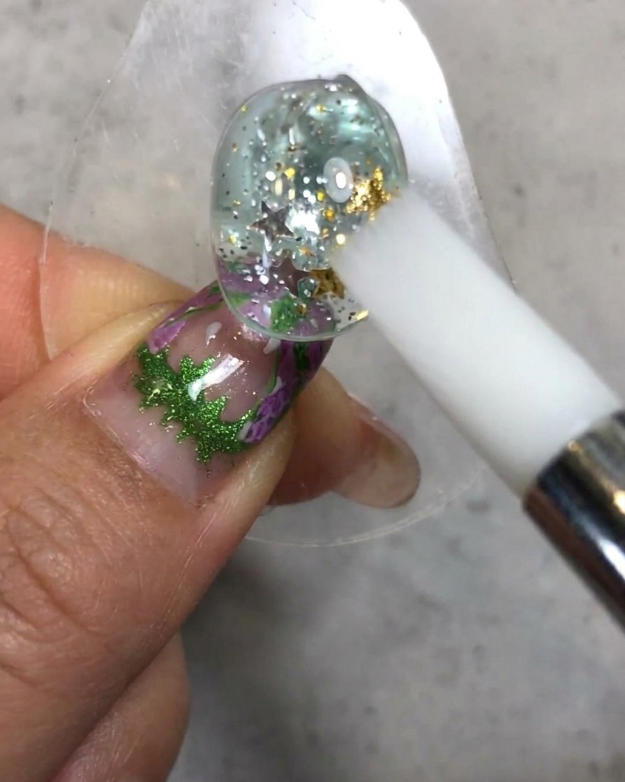 Ein weißer Silikonstift modelliert und glättet die Soft-Candy-Gel-Textur auf der dekorierten Nageloberfläche.