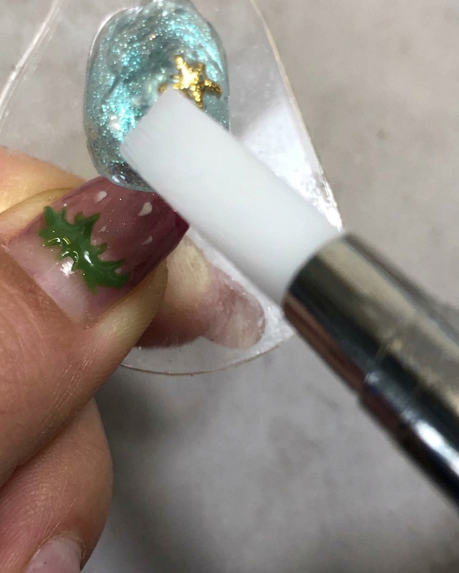 Eine Hand hält ein Silikon-Formwerkzeug in der Nähe eines Nagels unter einer Aushärtungslampe.