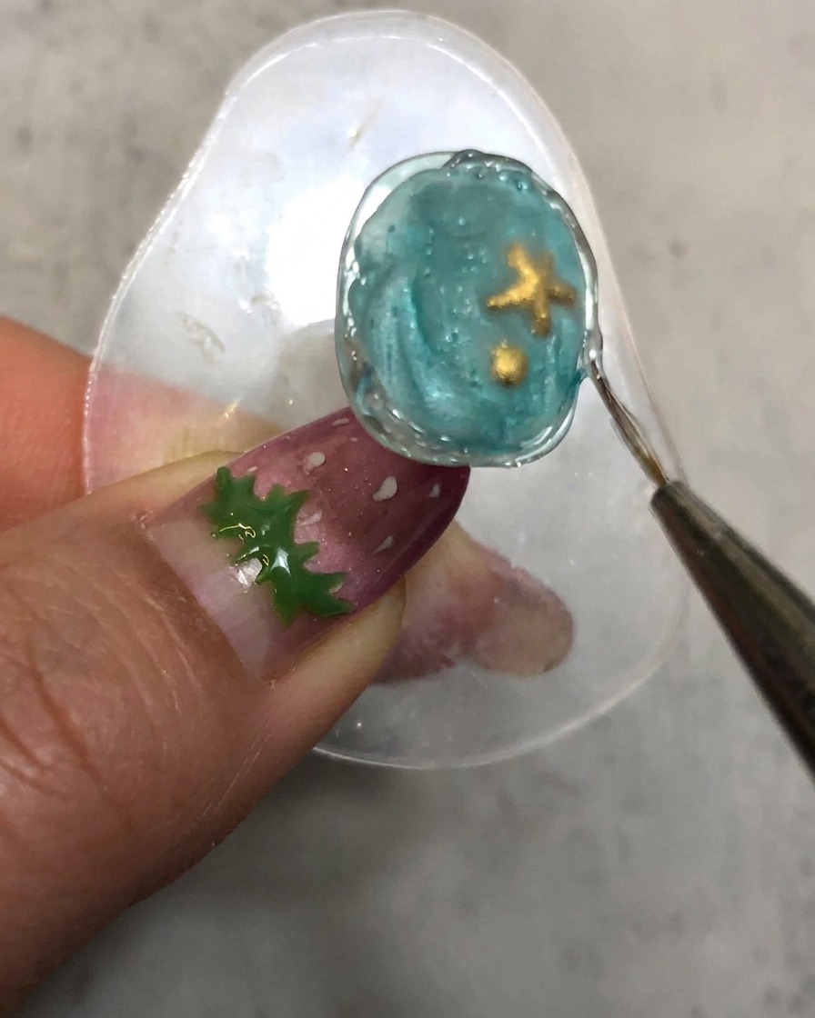Ein Detailpinsel zieht entlang der ausgehärteten, strukturierten Styling-Gel-Kante des Nagels.