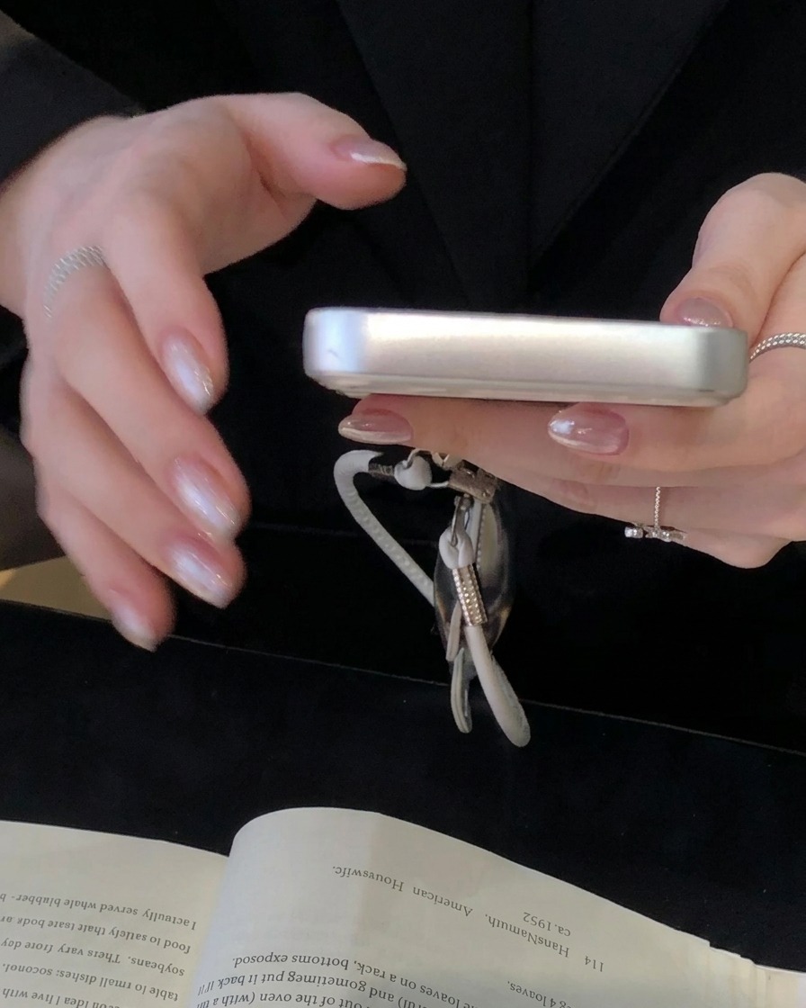 Nahaufnahme eines Schwamm-Stempels, der elfenbeinweißes Gel auf den Nagelhautbereich eines Nagels aufträgt.