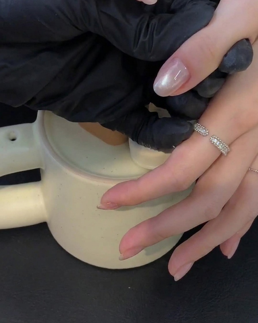 Eine Hand ruht in einer UV-Lampe und härtet Gelnägel aus.