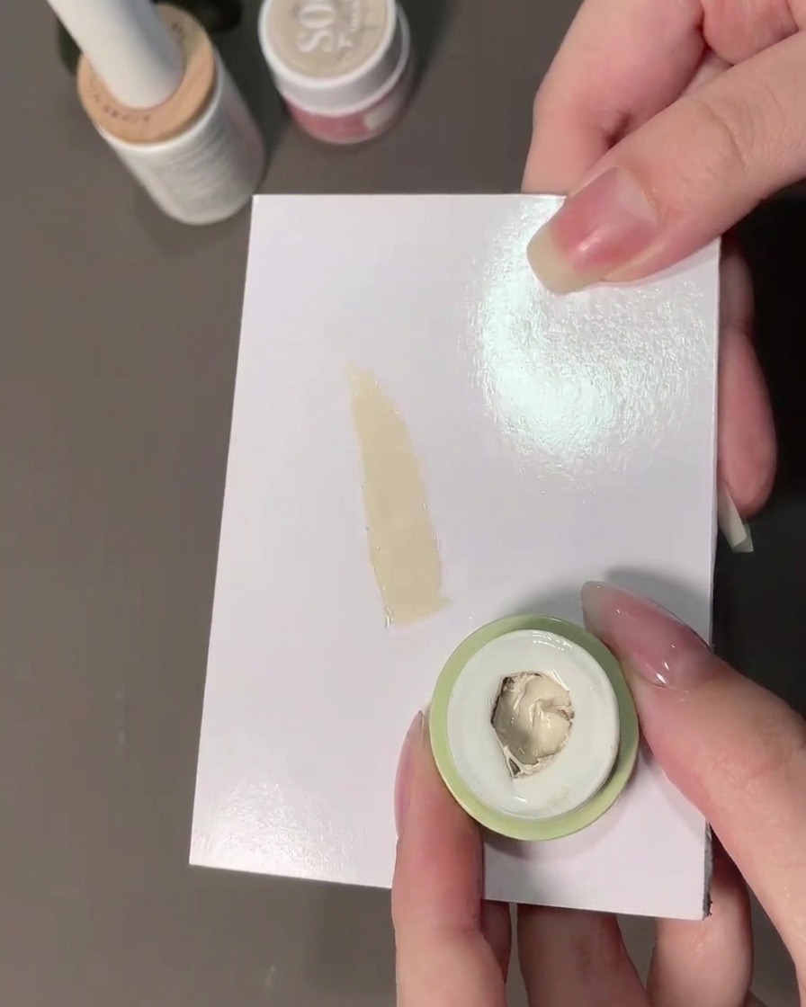 Ein Schwämmchen nimmt milchweißes Padding-Gel von einer Palette auf.