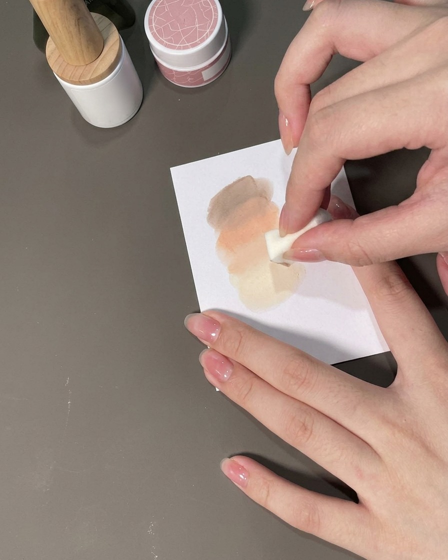 Ein Schwämmchen tupft Gel auf einen Nagel, um einen Ombré-Farbverlauf zu bilden.