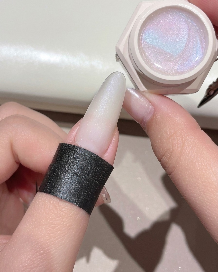 Ein Gelpinsel trägt ein schimmerndes, klares Cat-Eye-Gel auf den vorbereiteten Nagel auf.