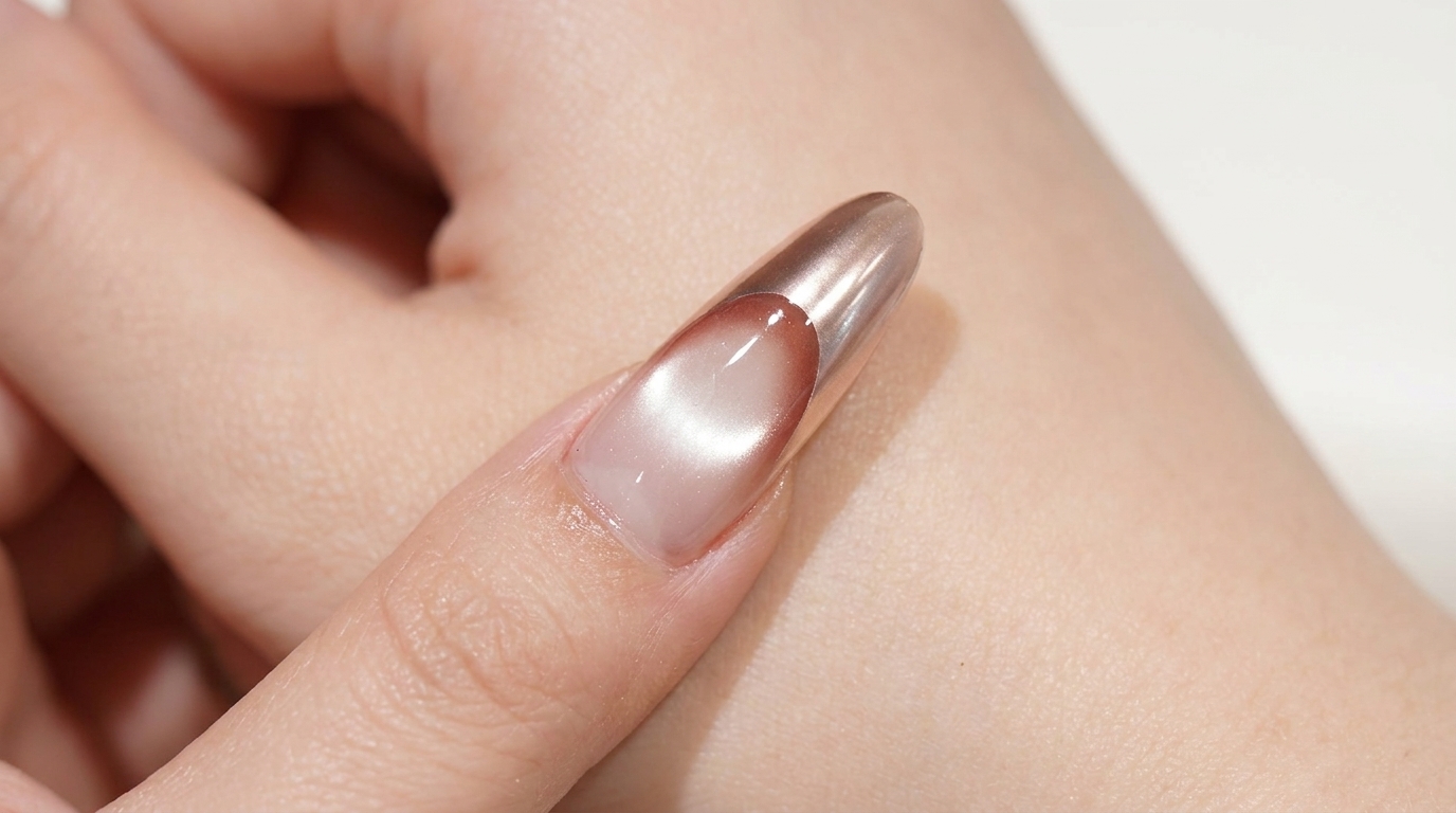 Lange, mandelförmige French Cat Eye Nägel in Roségold mit einem leuchtenden magnetischen Zentrum und einer metallischen Chrome-Spitze.