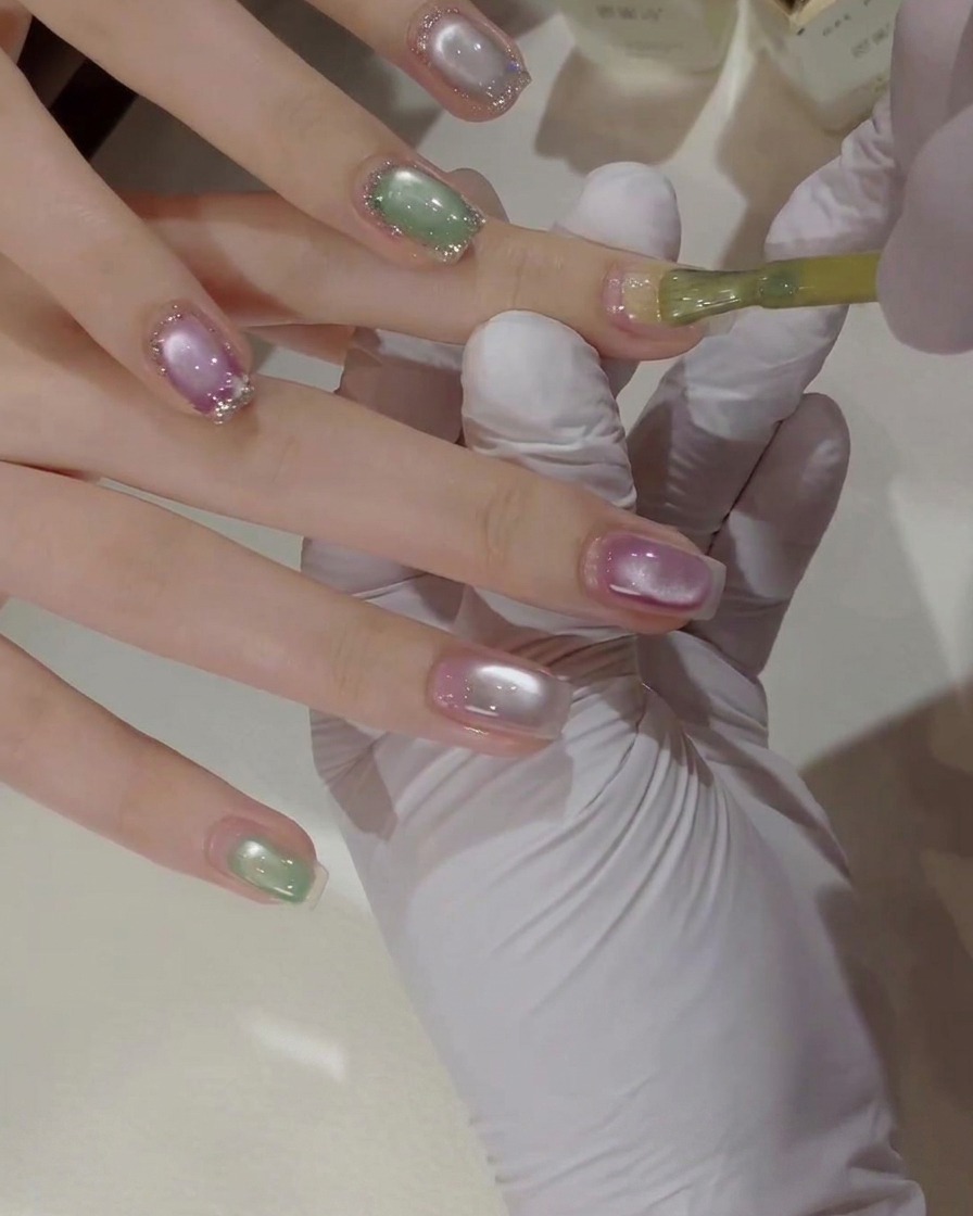 Eine detaillierte Nahaufnahme eines Nagelpinsels, der leuchtend gelben Gel-Nagellack auf einen Naturnagel aufträgt.