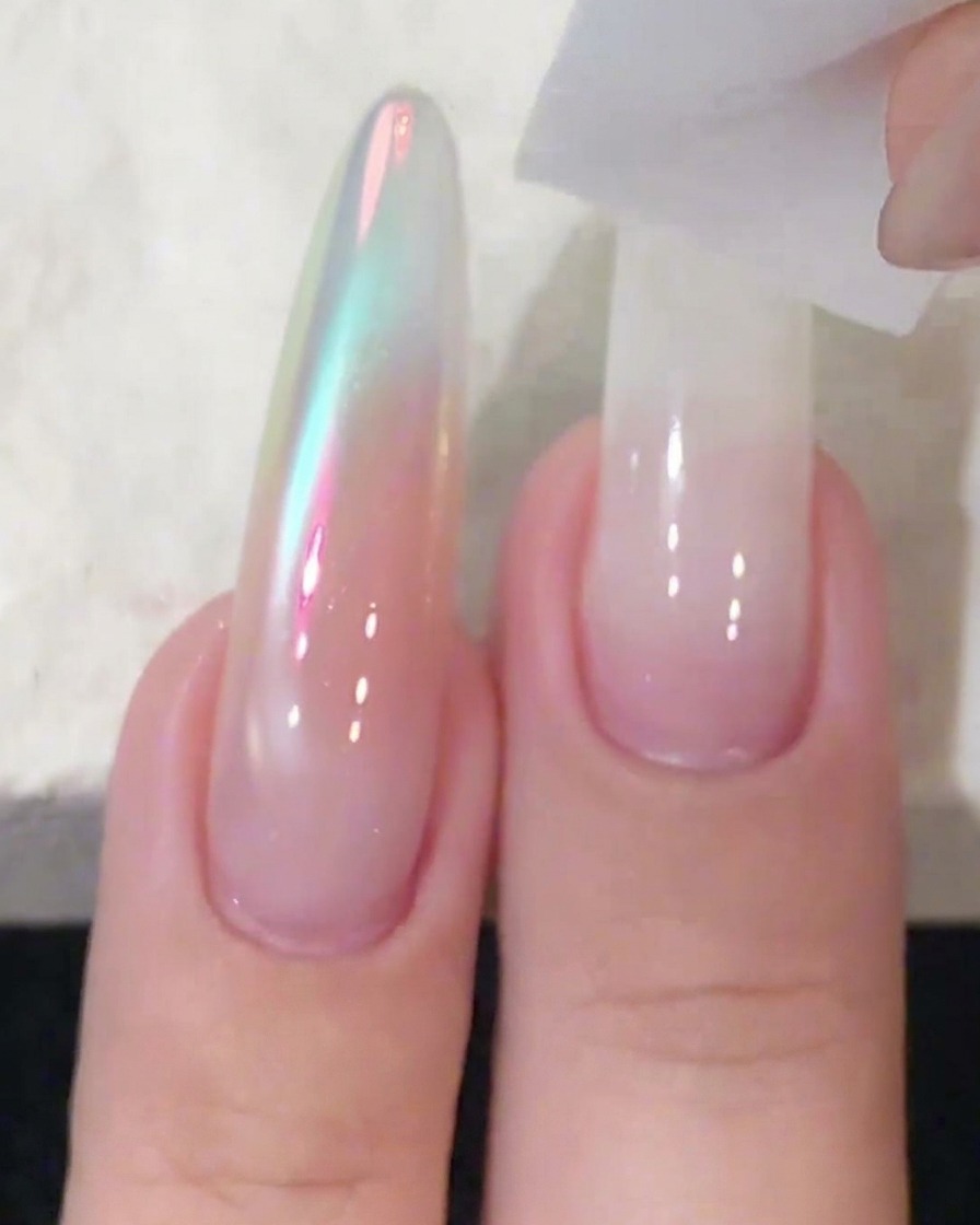 Ein Schwammblock wird verwendet, um weißes Gel-Polish auf einer langen Nagelverlängerung zu tupfen und zu verblenden.