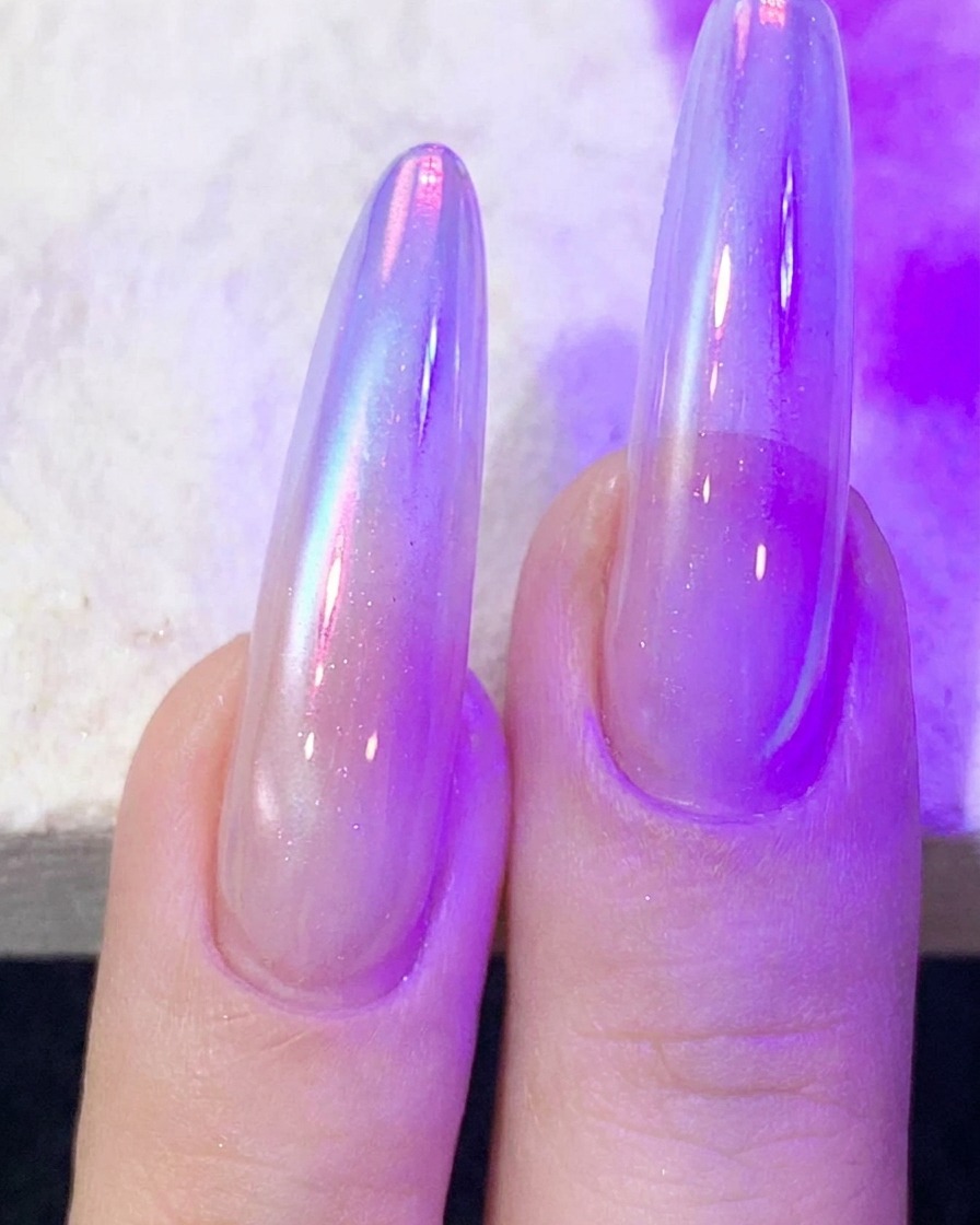Finger mit Cat-Eye-Nagelgel härten unter einer lila UV/LED-Nagellampe aus.
