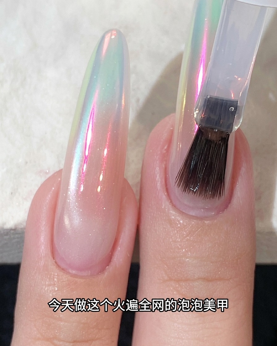 Ein Pinsel trägt Top-Coat über einen schimmernden, chrom-veredelten Nagel auf.