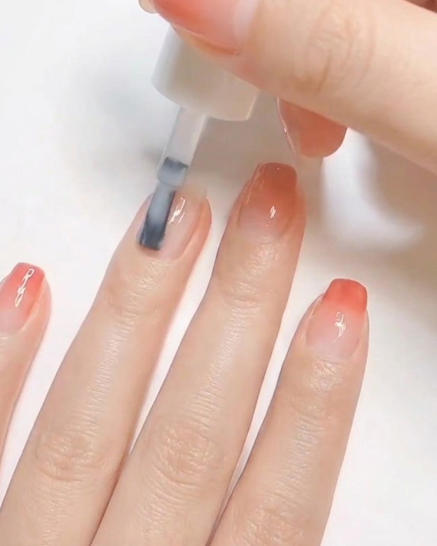 Ein Nagelpinsel trägt eine Schicht opaken weißen Lack auf einen vorbereiteten natürlichen Fingernagel auf.