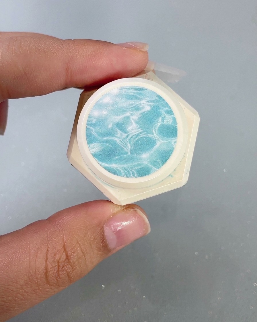 Ein Behälter mit hochtransparentem Glasgel und einem Wasserwellenmuster auf dem Etikett.