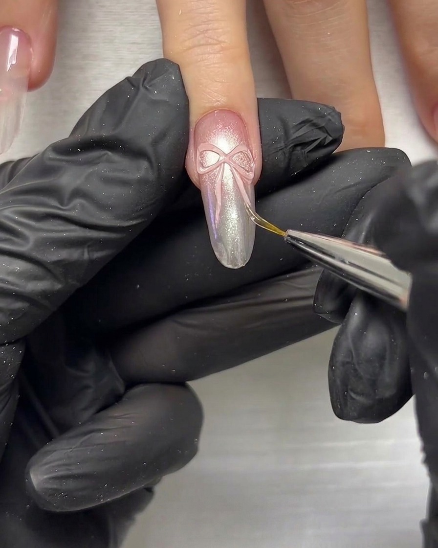 Eine Nahaufnahme eines Detailwerkzeugs, das verwendet wird, um 3D-Schleifenelemente auf einem Nagel anzudrücken und zu formen.