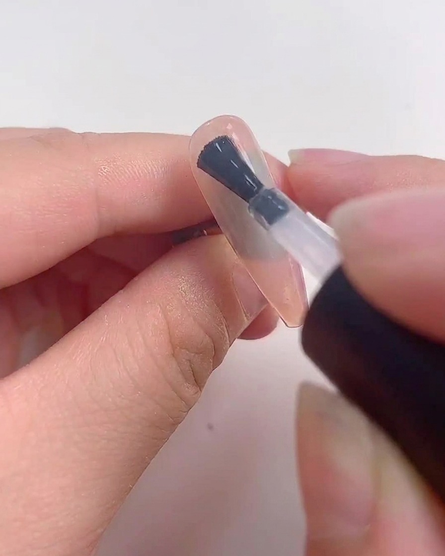 Ein Nagel liegt während des Aushärtens unter einer UV- oder LED-Lampe.