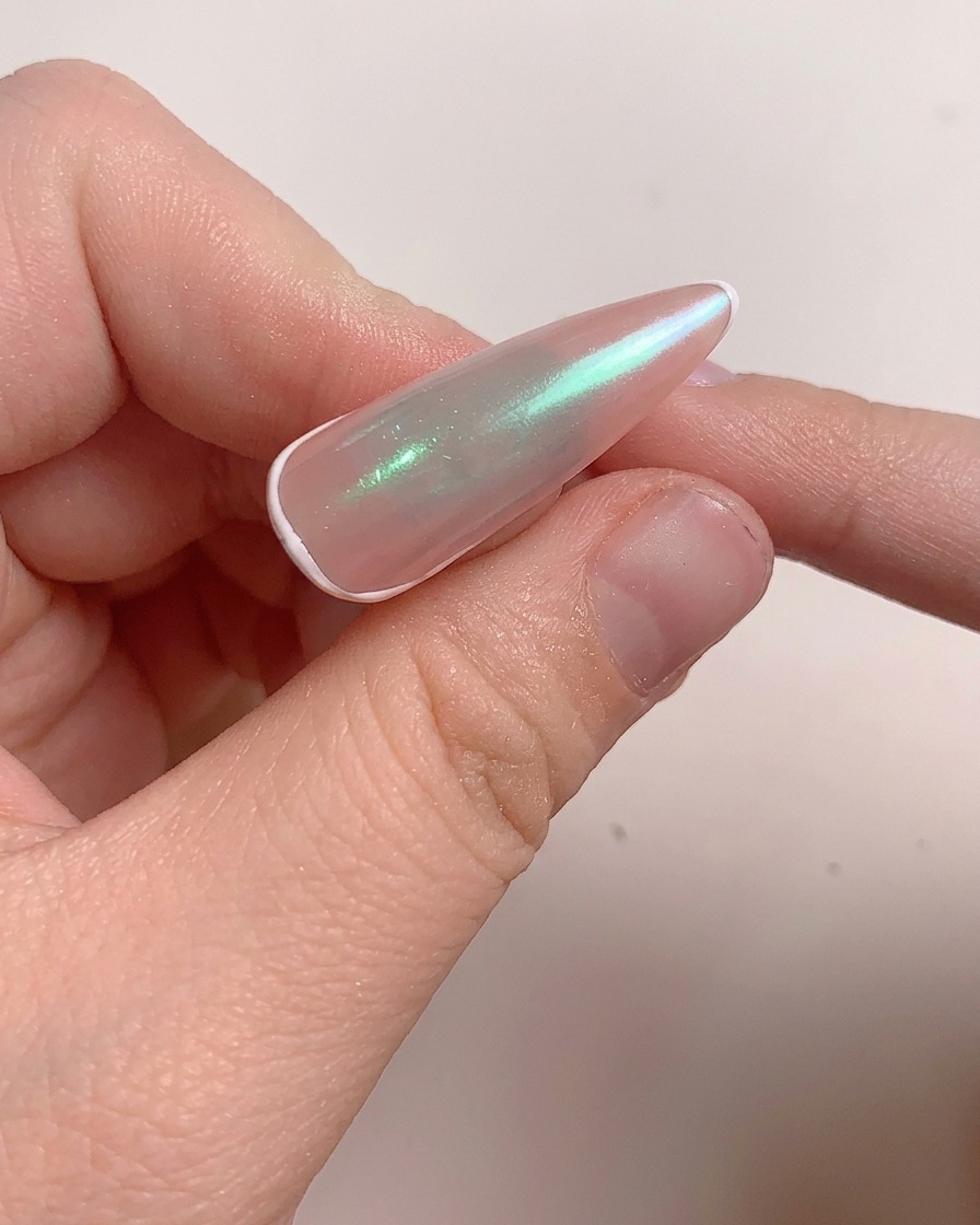 Ein Pinsel trägt eine Schicht Aufbaugel auf den polierten Nagel auf.