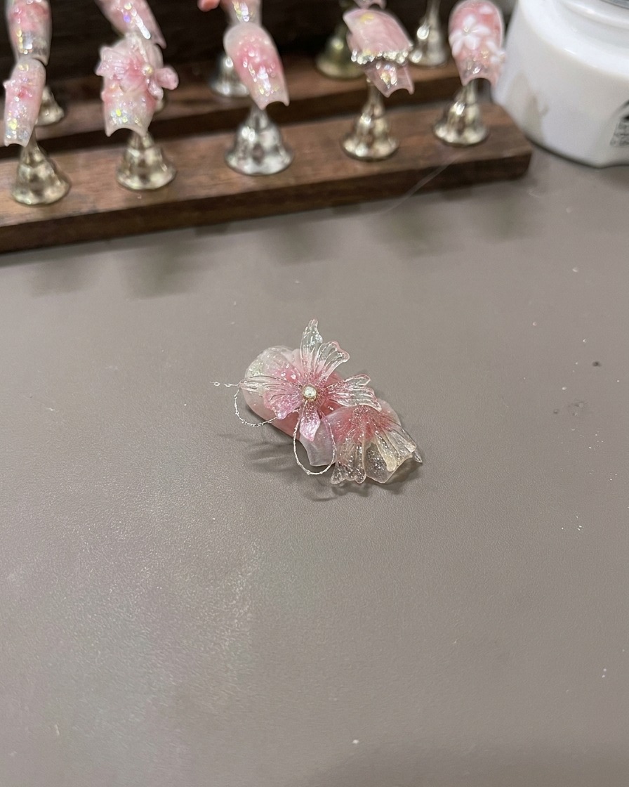 Die fertiggestellten 3D-Schmetterlingsflügel ruhen auf einer Display-Oberfläche vor der finalen Nagelplatzierung.