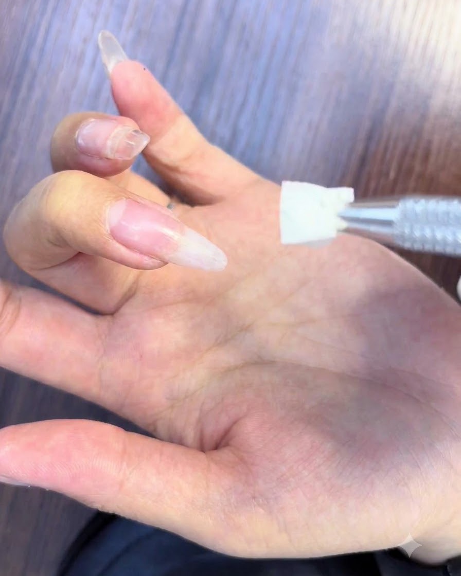 Auftragen von weißem und rosafarbenem Blooming Gel auf eine Nageloberfläche, um einen Ombré-Effekt zu erzielen.
