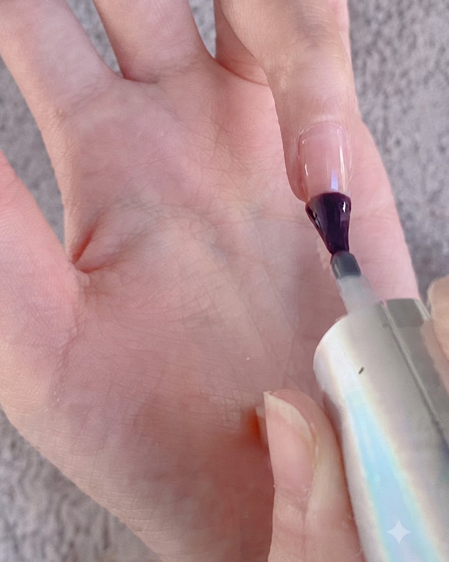 Ein Nagelpinsel trägt Gel auf eine Fingeroberfläche zur Vorbereitung auf Chrompuder auf.