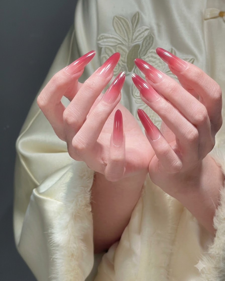 Zwei ineinandergelegte Hände präsentieren alle Finger, um eine vollständige festliche rote Ombré-Maniküre zu zeigen.