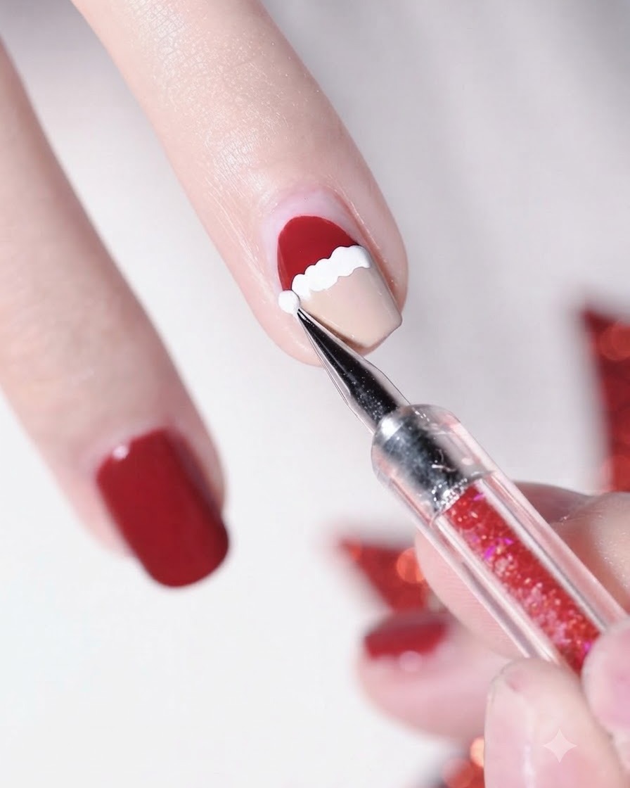 Nahaufnahme eines Dotting-Pens, der einen weißen Punkt auf die Spitze der roten Weihnachtsmütze setzt.