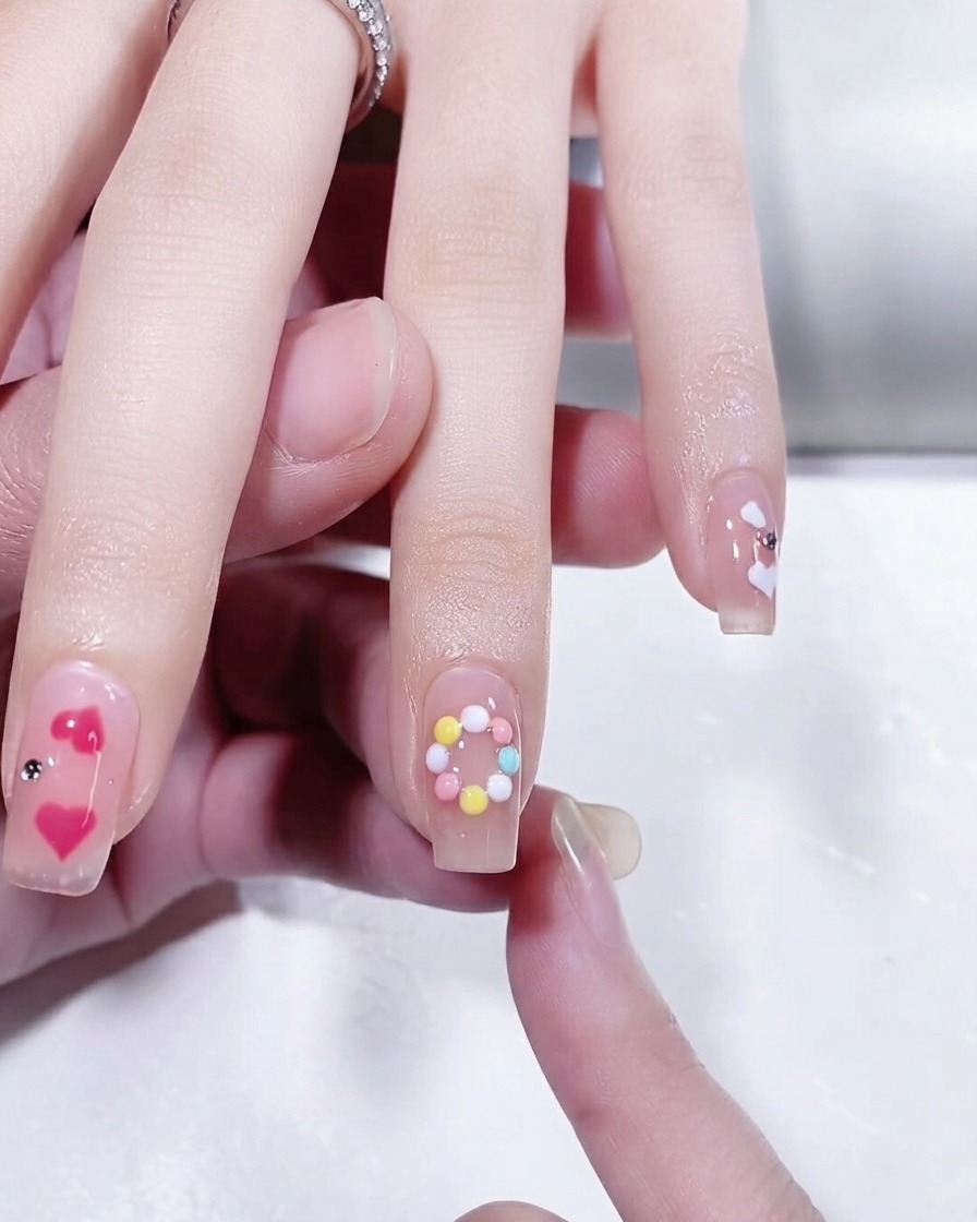 Nahaufnahme eines Fingernagels mit einem fertigen pastellfarbenen, kreisförmigen Ringdesign.