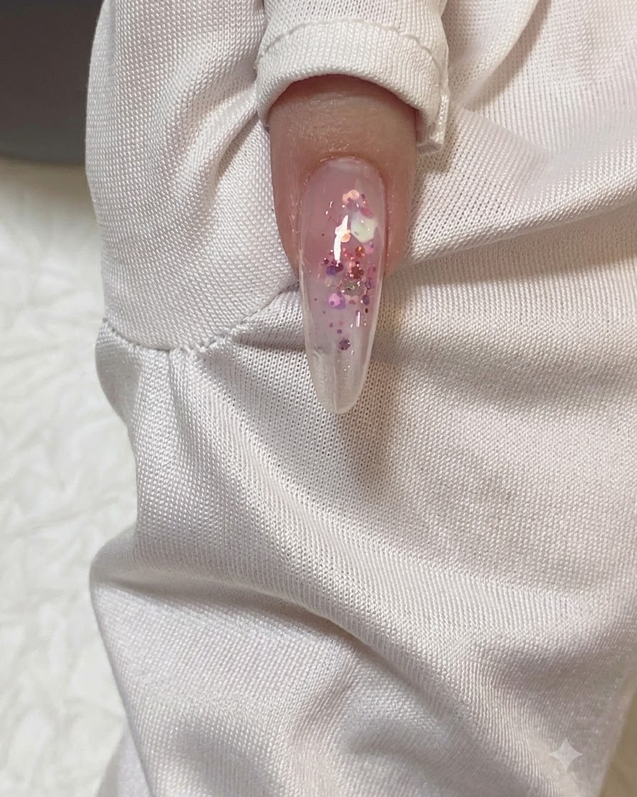 Nahaufnahme eines mandelförmigen Nagels, der eine klare Schicht Builder-Gel erhält.