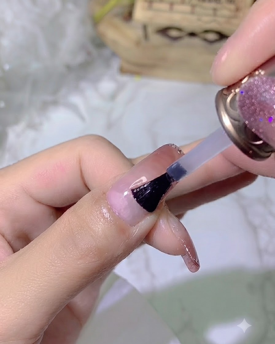 Ein Pinsel, der einen klaren, glänzenden Top-Coat auf einen manikürten Nagel aufträgt.