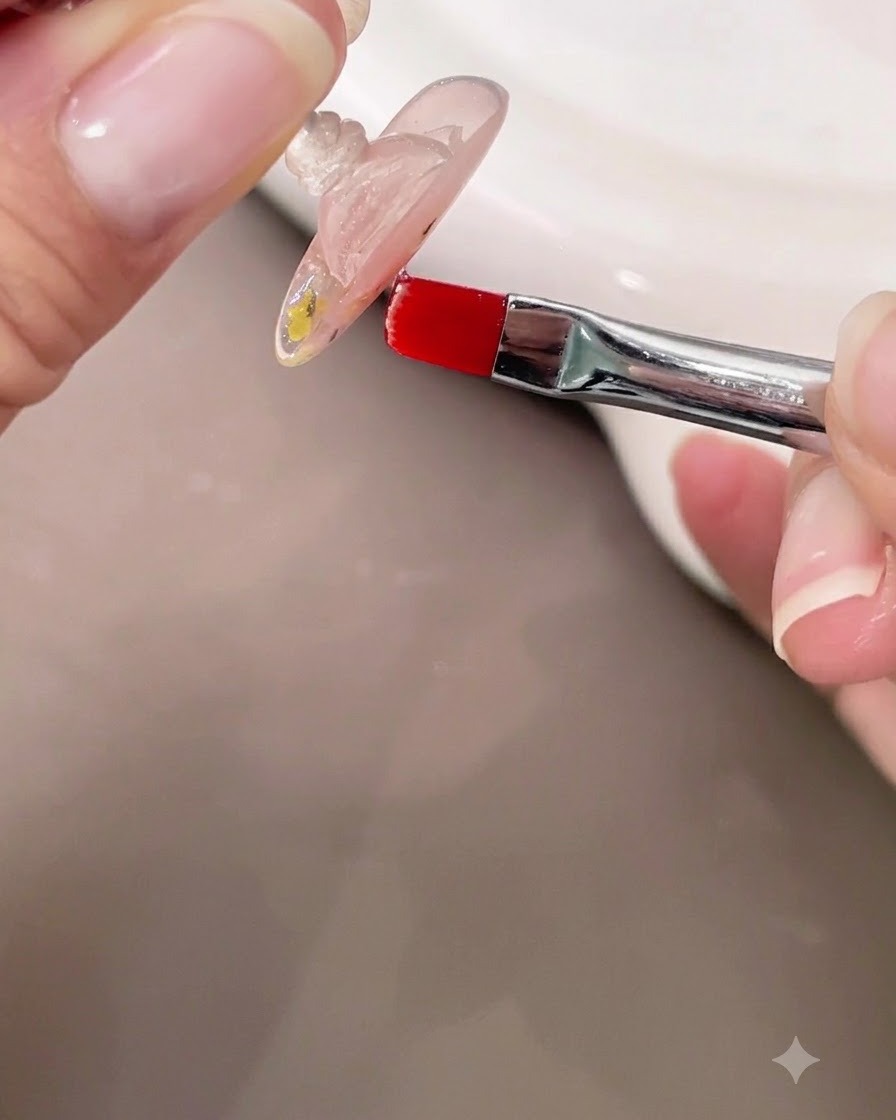 Eine Hand hält einen Nagel kopfüber, während ein kleiner Pinsel den sich selbst nivellierenden klaren Builder-Gel-Apex überprüft.