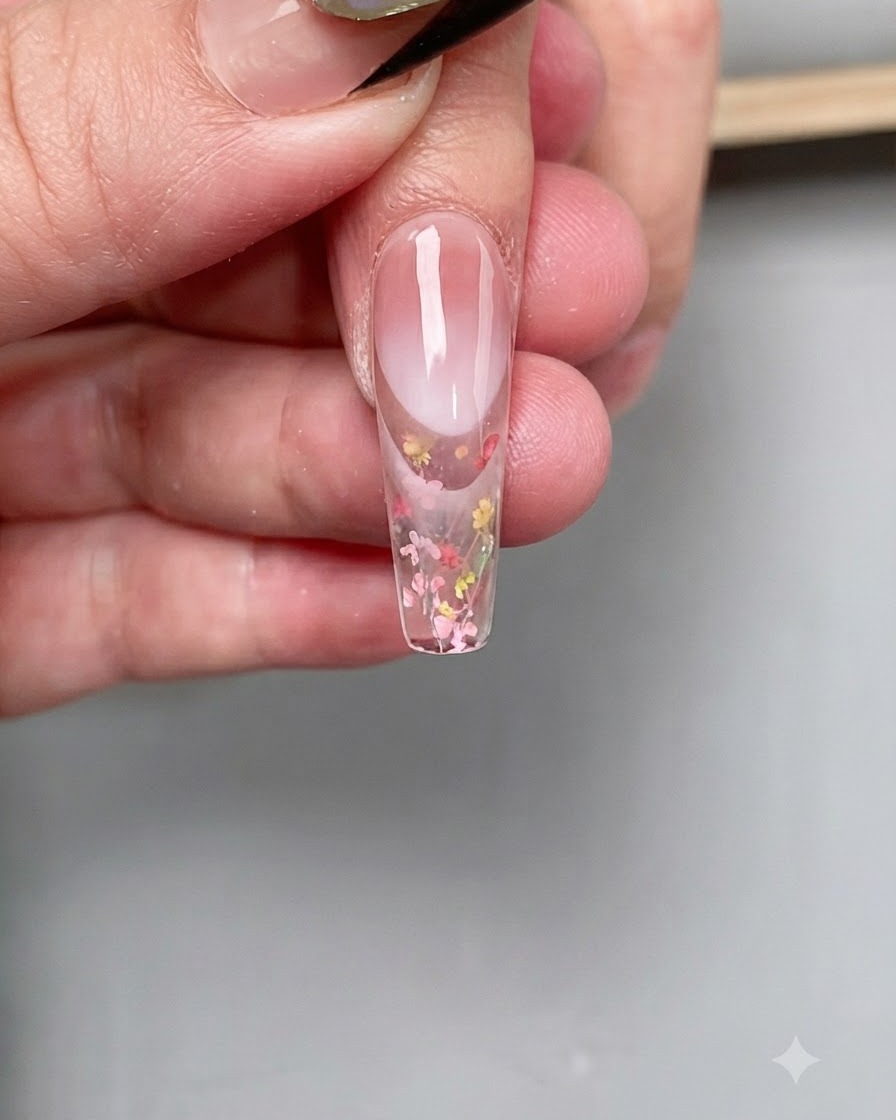 Ein Fingernagel wird während des Aushärtungsprozesses unter einer UV-Nagellampe positioniert.