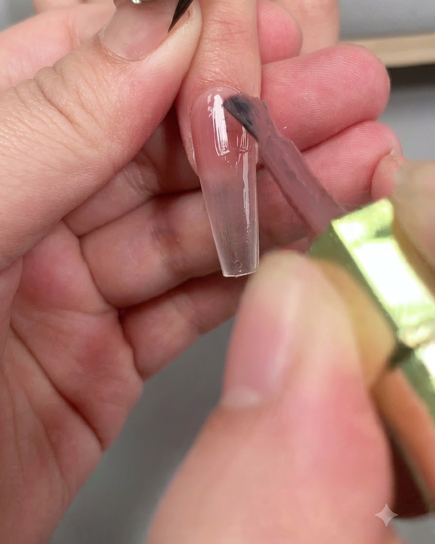 Ein Pinsel trägt eine glänzende Schicht Diamant-Top-Coat über die gesamte Nagellänge auf.