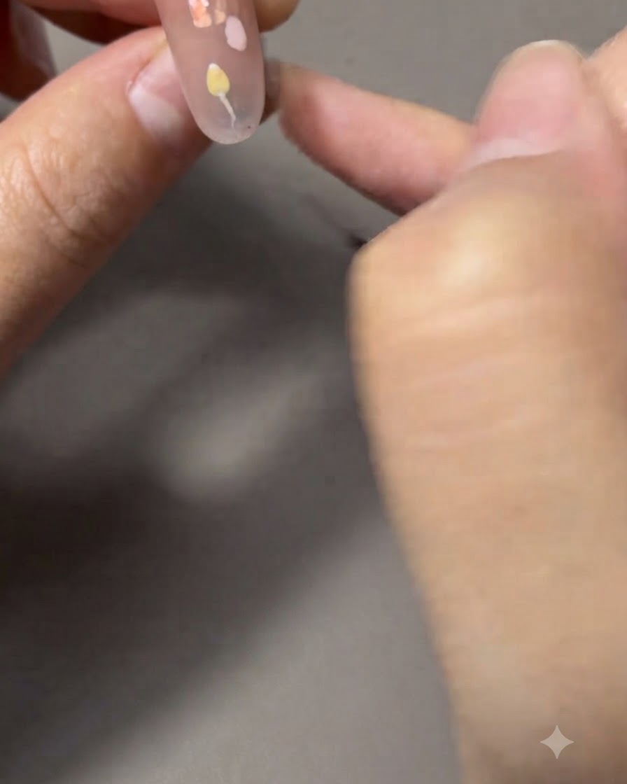 Ein feiner Liner-Pinsel malt dünne grüne Stängel und Blätter, die mit einer Tulpe verbunden sind.