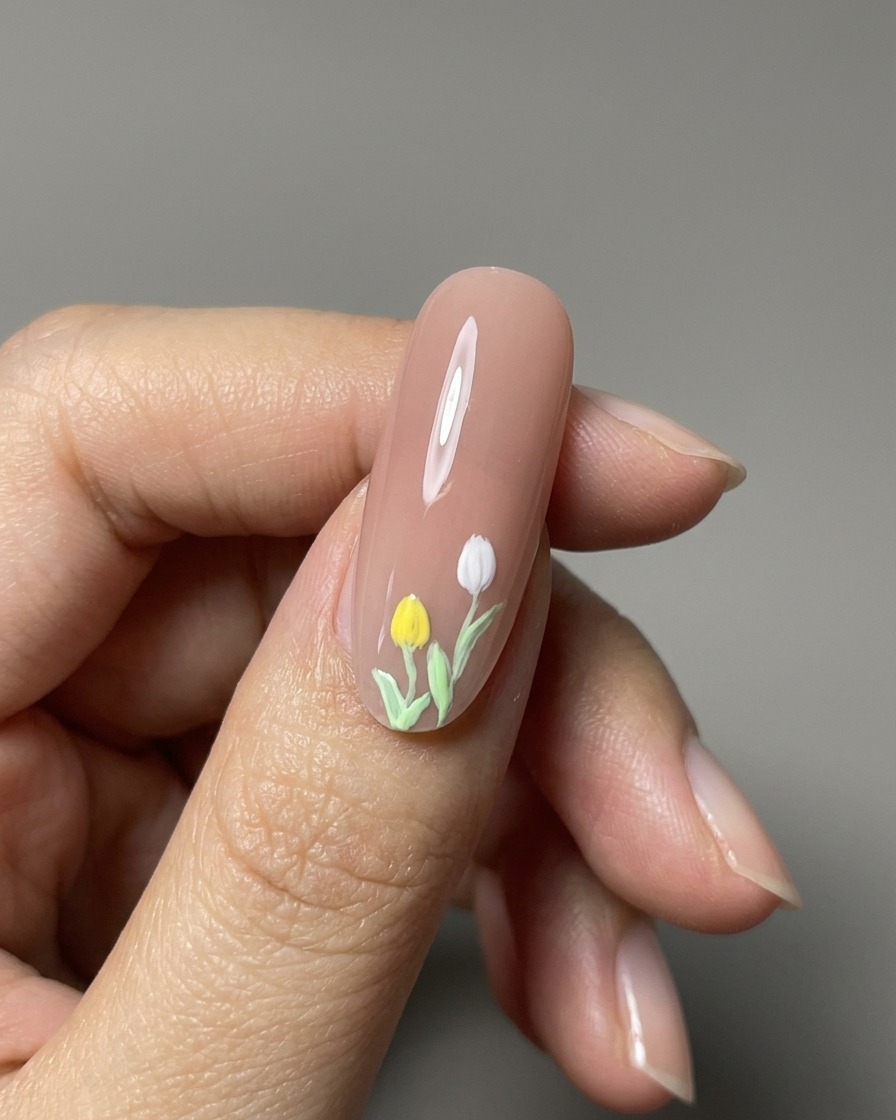 Nahaufnahme von fertigen 3D-gemalten Tulpen auf einem glänzenden Nude-Nagel.