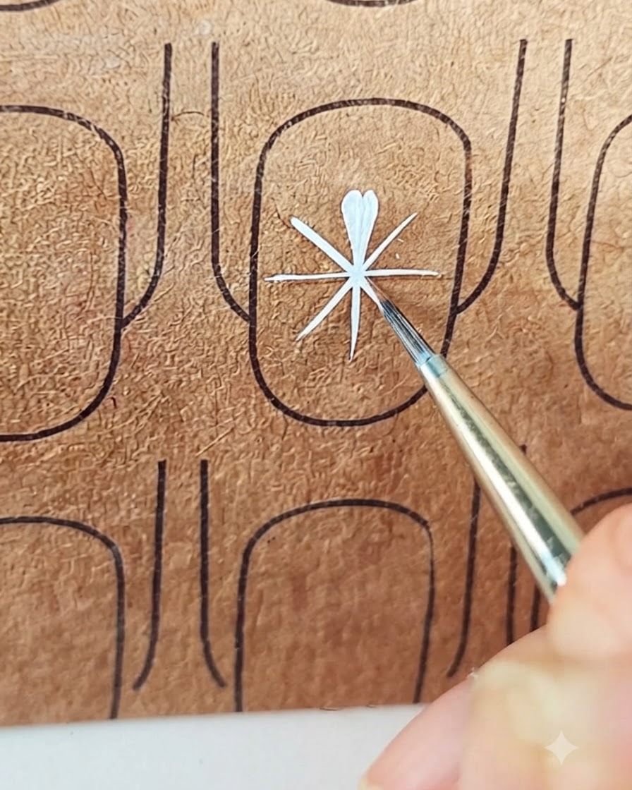 Ein Liner-Pinsel fügt den zweiten Strich hinzu, um ein weißes Blütenblatt in eine weiche Tropfenform zu bringen.