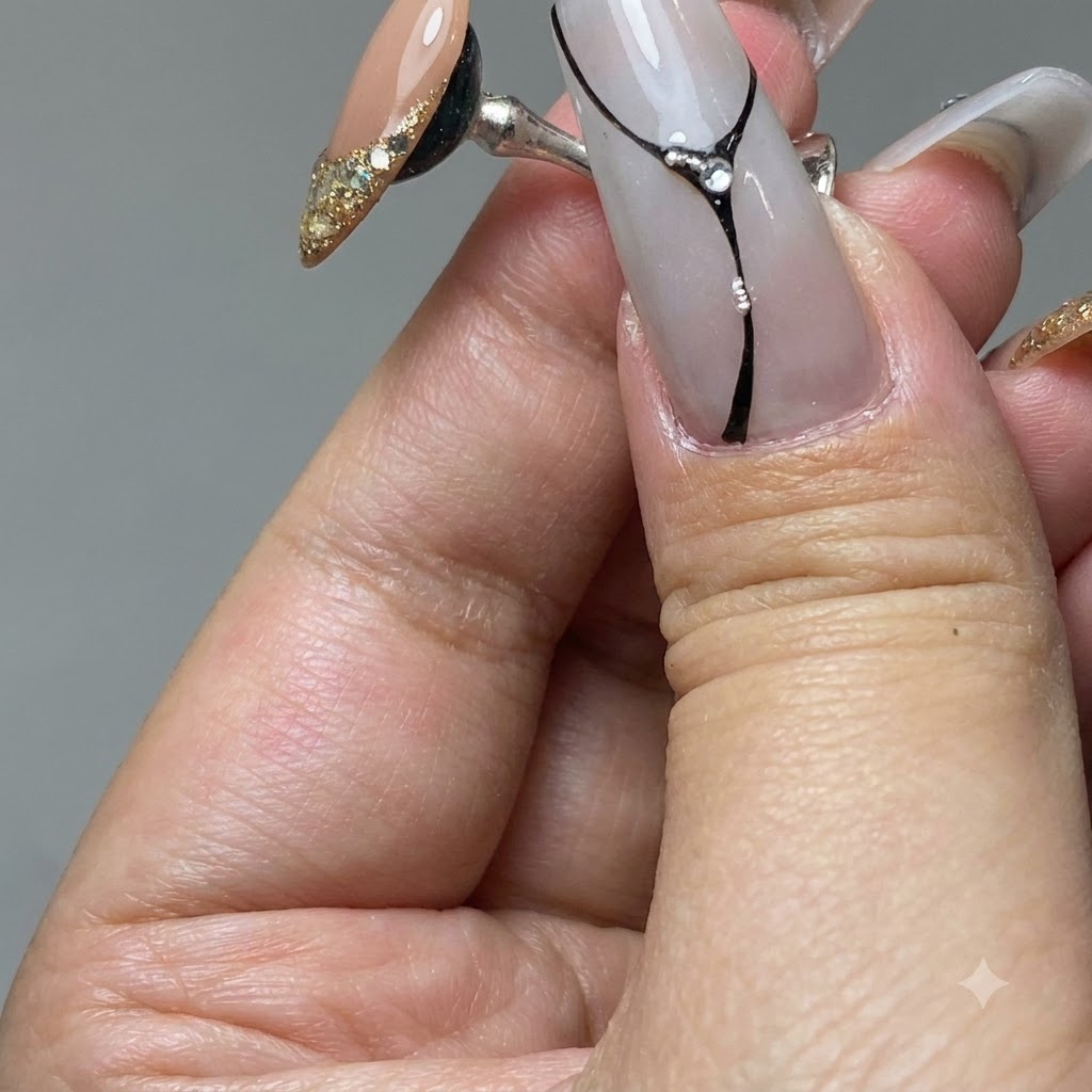 Ein Nagelpinsel verteilt Gold-Platingel über der Spitze eines Übungsnagels.