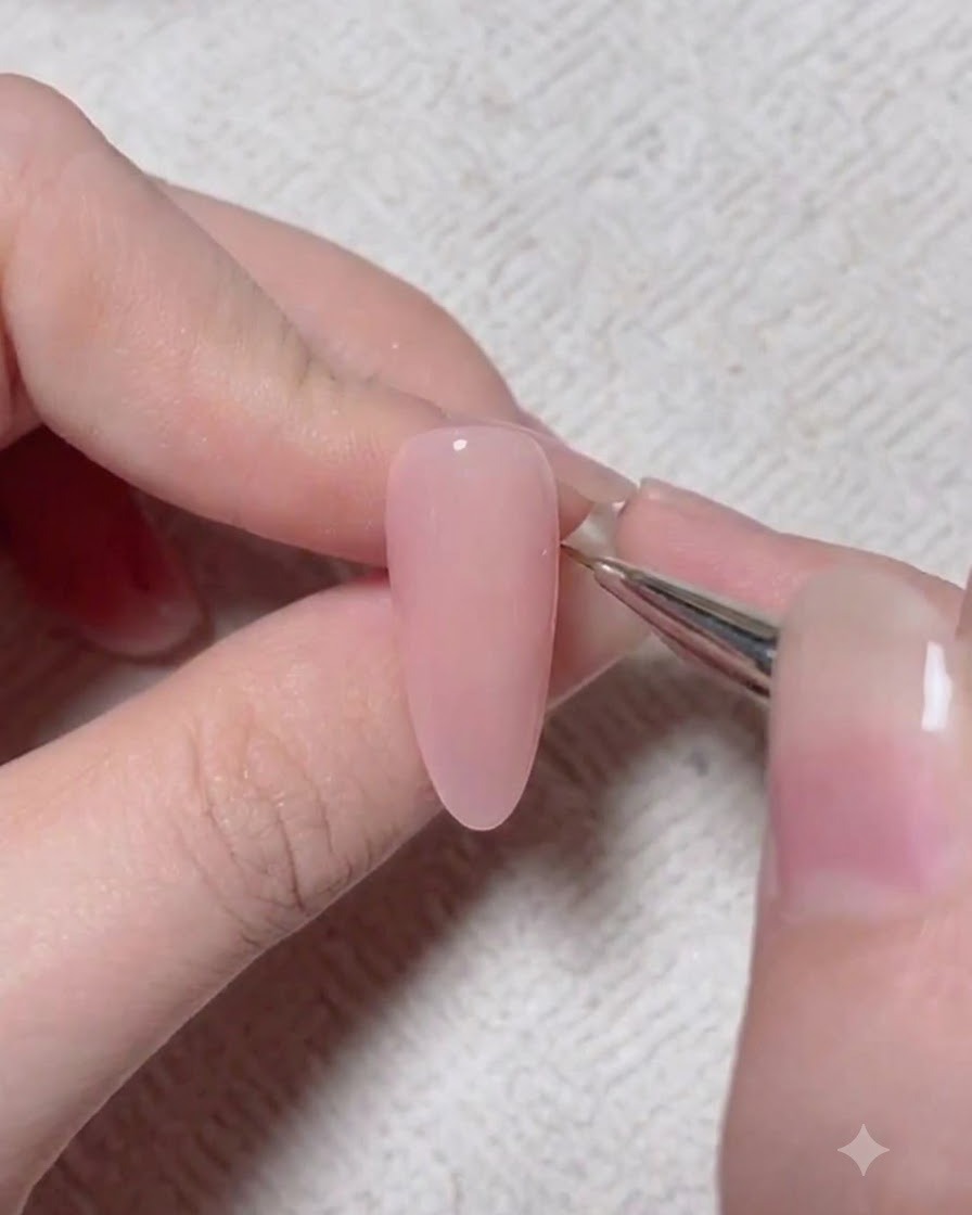 Ein Detailpinsel trägt ein dunkleres Akzentpigment auf eine rosa Gel-Nageloberfläche auf.