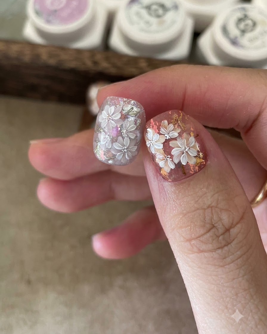 Eine Nahaufnahme von Pinzetten, die irisierende Folienflocken auf eine klebrige Gelbasis auf einem Fingernagel platzieren.