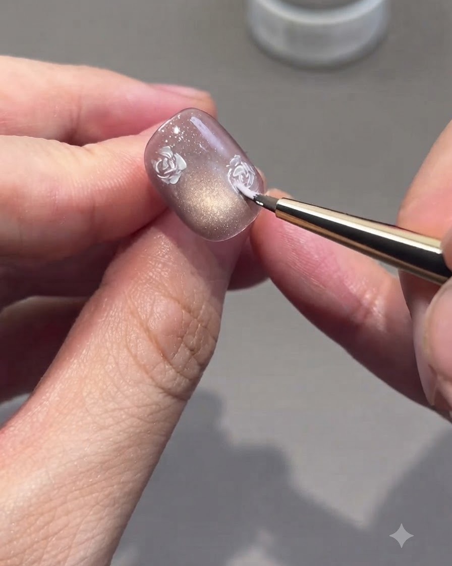Ein feiner Pinsel füllt die Rosenumrisse mit rosa Gel-Nuancen auf einem Nagel aus.