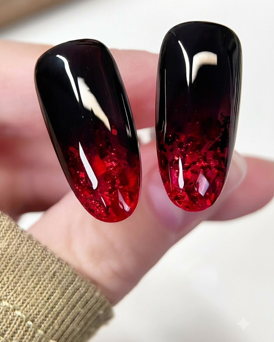 Ein kleiner Nagelpinsel trägt schwarzes Gel mit einer Tupfbewegung auf den oberen Teil eines Mandelnsnagels auf.