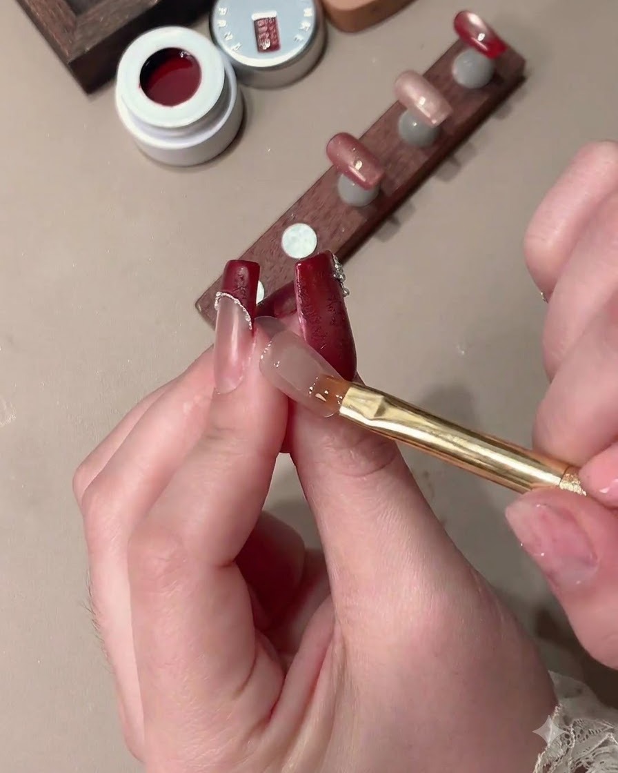 Ein Magnet formt Cat-Eye-Gel auf einem Nagel zu einem breiten Lichteffekt mit klarer French-Spitzen-Aussparung.
