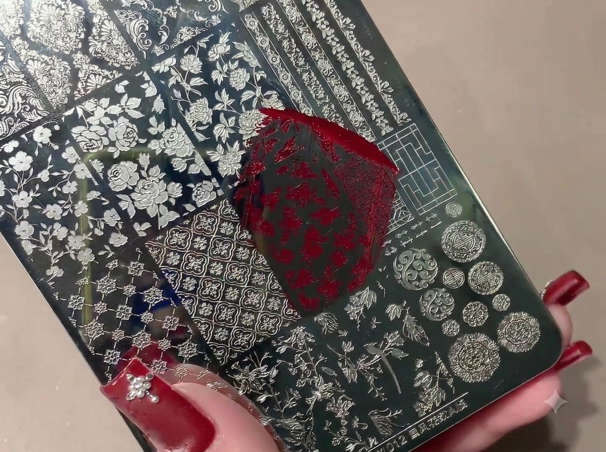 Ein Silikon-Stamper nimmt ein rotes gestempeltes Muster von einer Metall-Stamping-Platte auf.