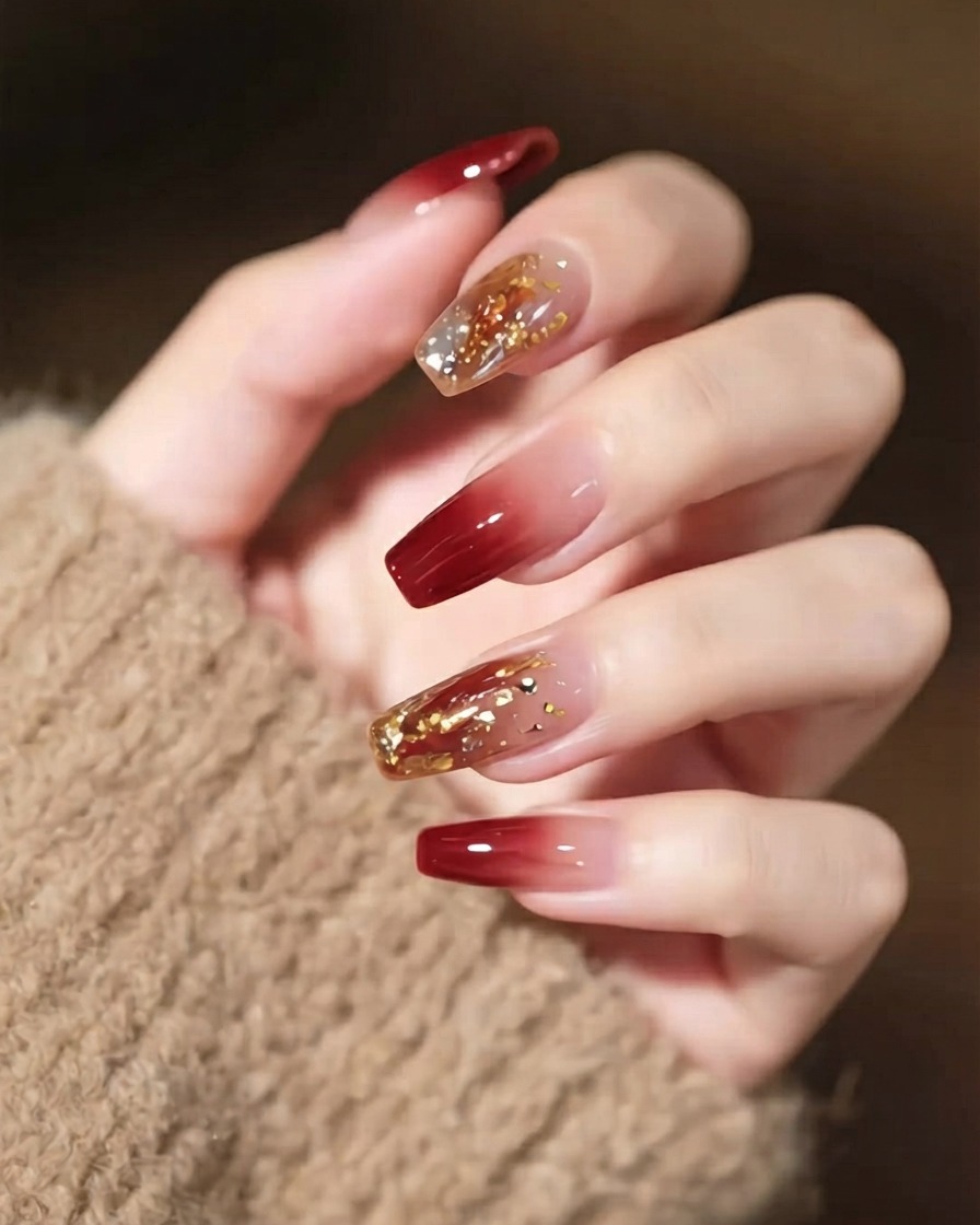 Eine Nahaufnahme einer Hand mit detaillierter Nailart, die einen prominenten Statement-Kristall und dünne goldene Linien zeigt.